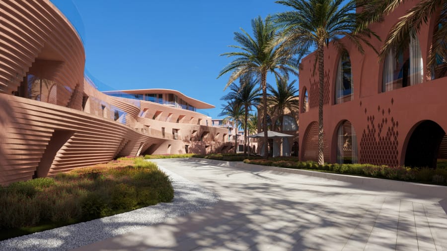 A landscaped courtyard between coral-inspired buildings at Mira Coral Bay